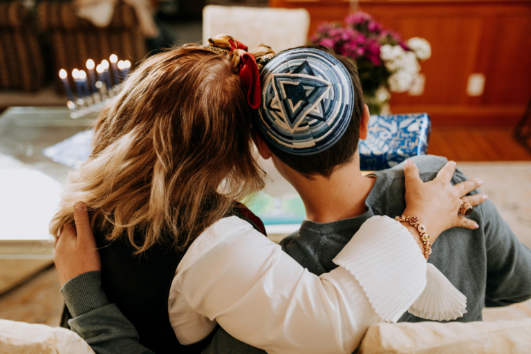 Jewish couple sitting in front of wedding flowers