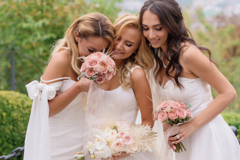 Trois mariées tenant des bouquets de roses romantiques