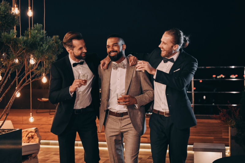 Trois hommes en costumes à un mariage