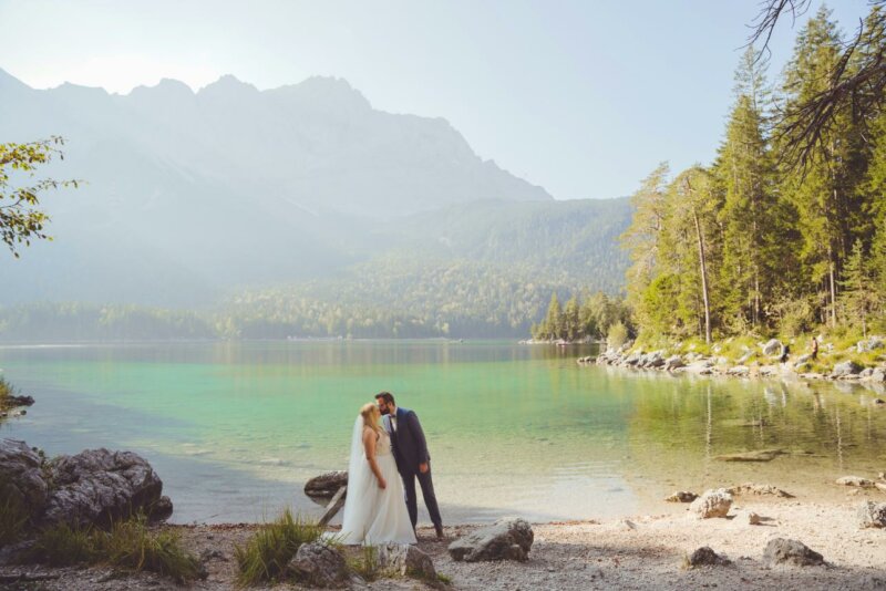 Couple de mariés dans un superbe paysage de montagne au bord d'un lac