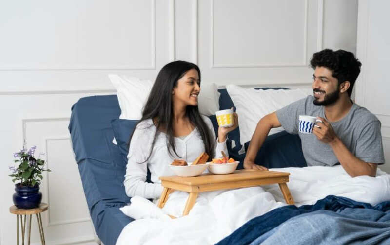 Couple en train de prendre un petit-déjeuner au lit