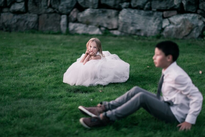 Page boy and flower girl sitting in the grass