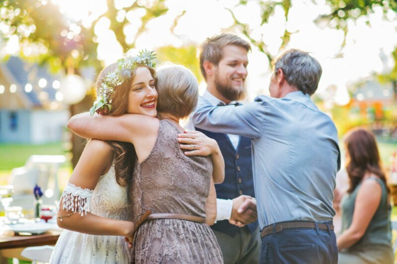 Newly weds couple hugging their parents