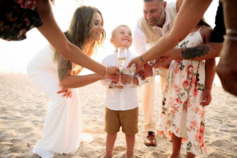 Child and adults toasting at an engagement party on the beach