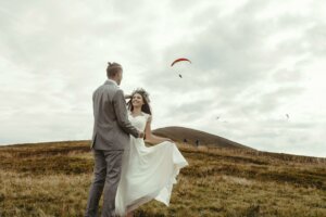 Mariés dans un champs avec un parapente