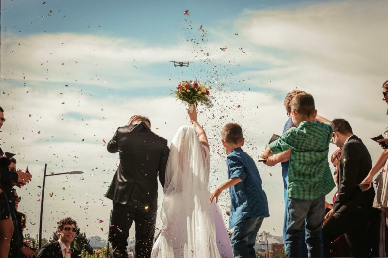 Newly wed couple with flower petals and page boys