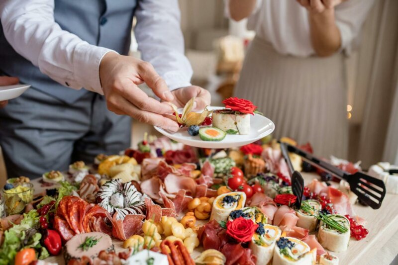 Groom eating from a wedding buffet