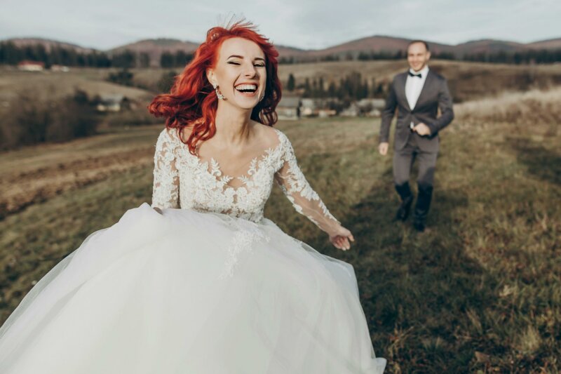 Laughing bride with groom in a field