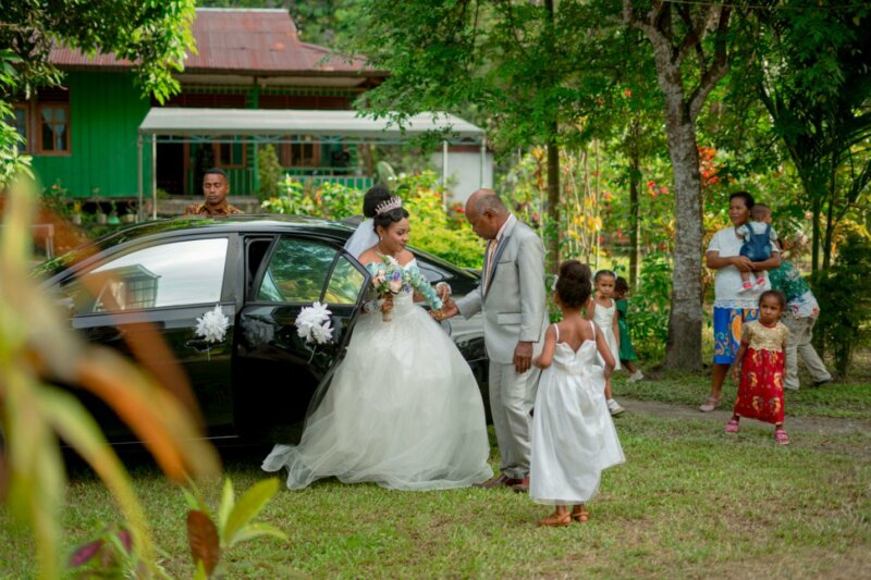 Bride coming out of a car with flower girl