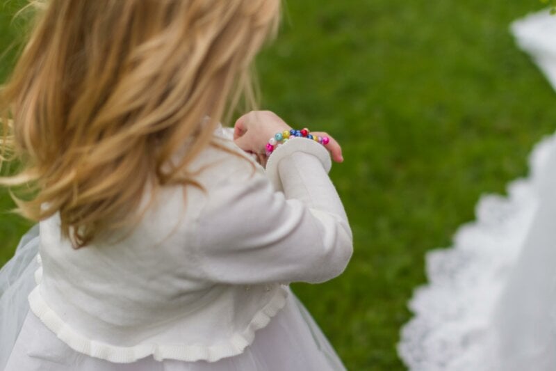 Flower girl looking at a bracelet