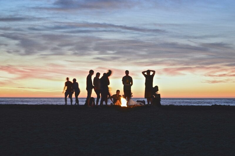 Amis autour d'un feu sur une plage