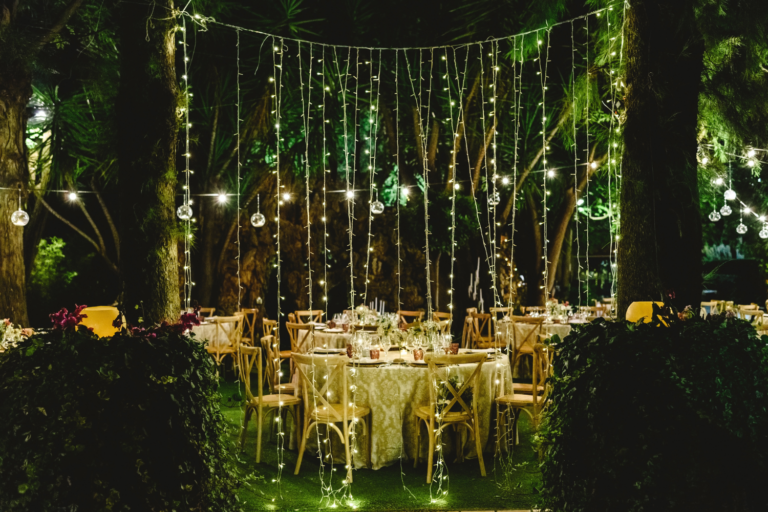 Table de mariage dans une forêt avec guirlandes lumineuses