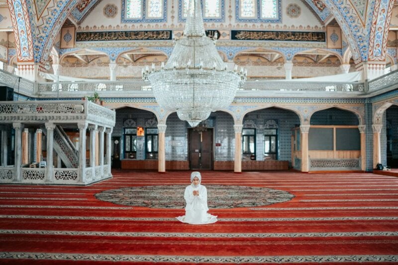 Bride praying in a Mosque with a big chandelier