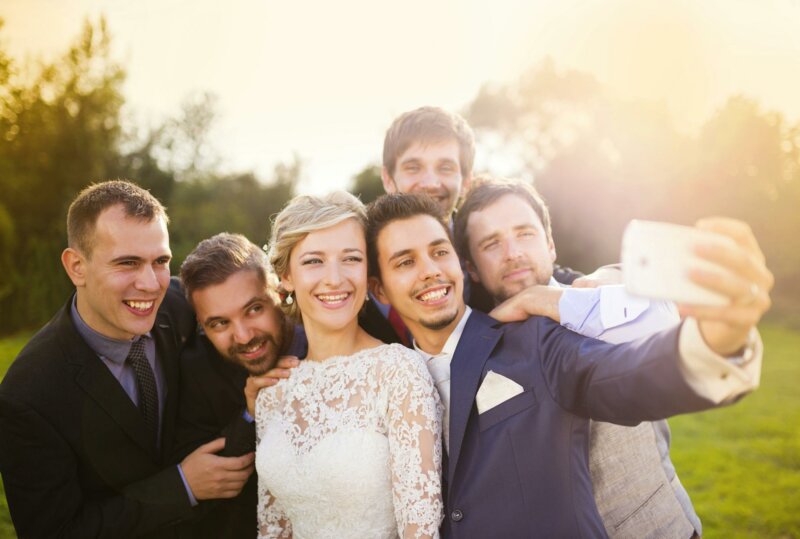 Mariés en train de prendre un selfie avec leurs invités