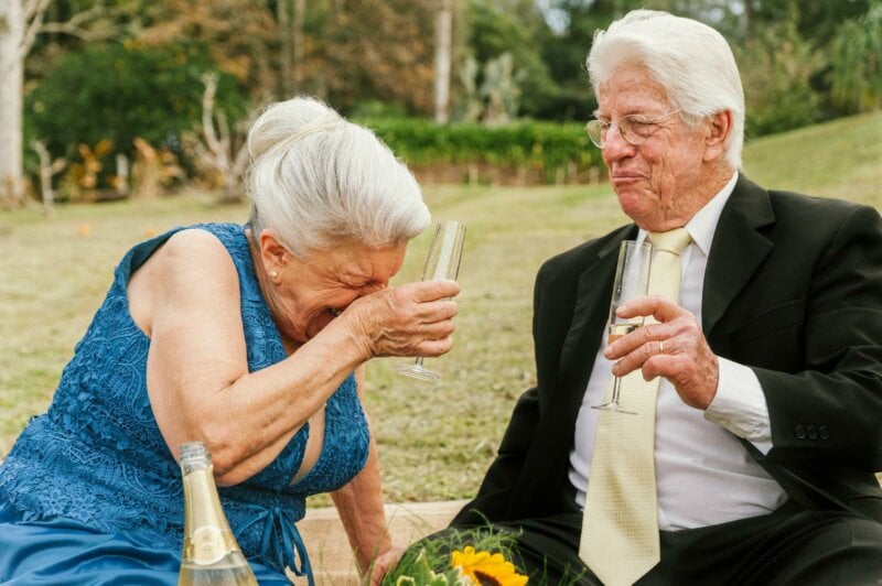 Deux seniors en train de boire et rire à une cérémonie