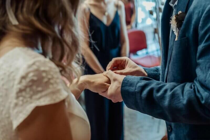 Groom putting a wedding ring on his bride's finger