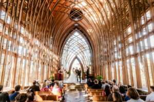 Couple getting married in a stunning wood cathedral