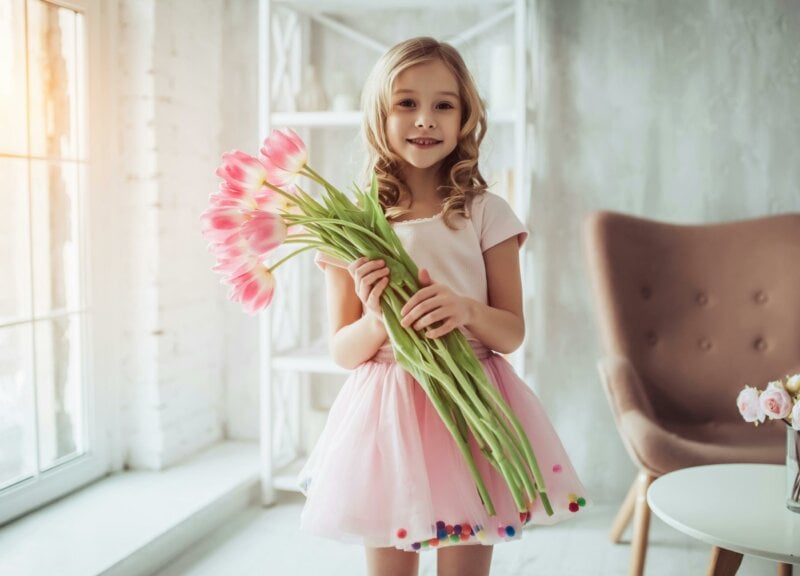 Little girl dressed in pink with a flower bouquet