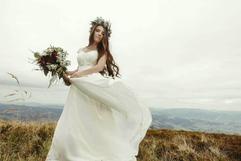 Bride in a field with a flower crown and bouquet