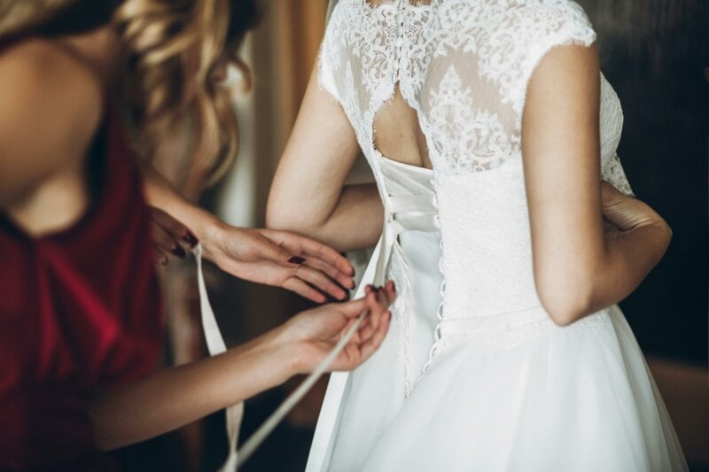 Tailor adjusting a wedding dress