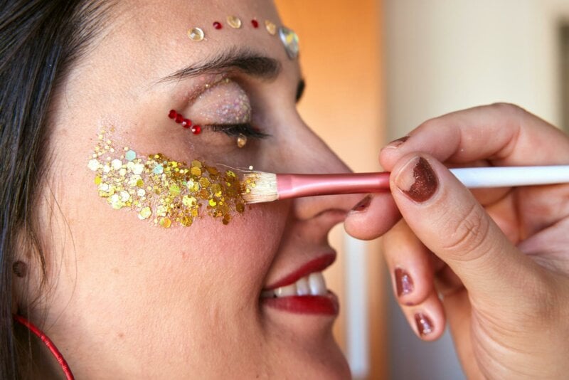 Woman getting a face make up with glitter