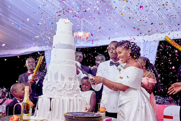 Un couple de mariés en train de couper un gâteau de mariage 