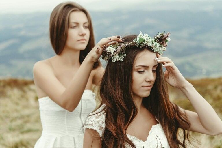 Mariée avec boucles lâches et une couronne de fleurs, et sa demoiselle d'honneur