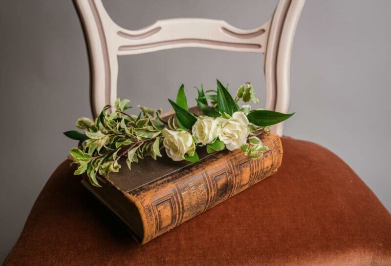 Old book with white roses on a chair