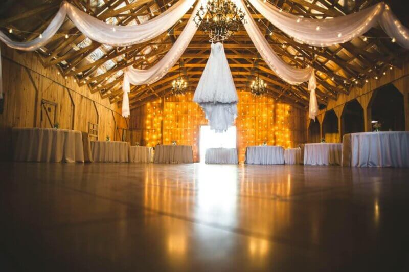 Salle de mariage décorée avec des draperies, une robe de mariée et un lustre