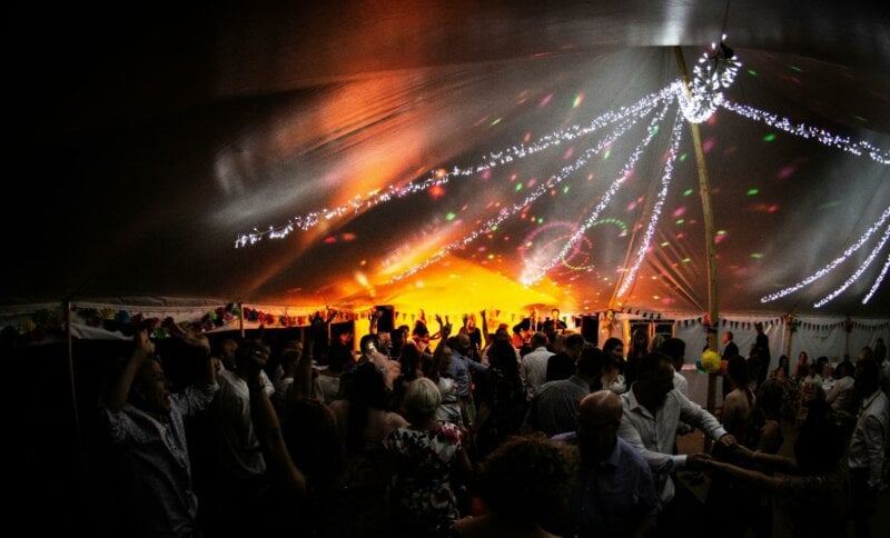 Huge tent with lights and dancing guests