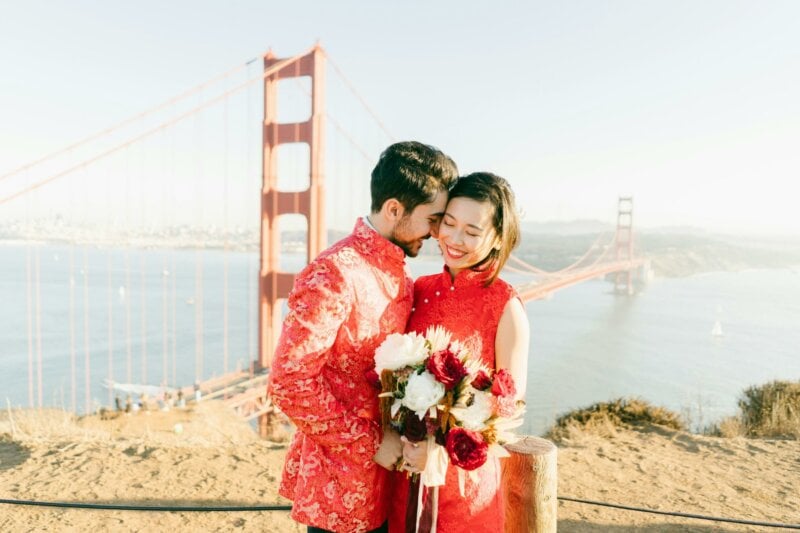 Asian couple in front of the Golden Gate with a bouquet