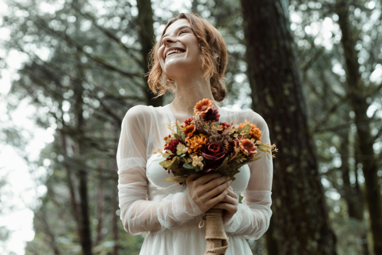 Mariée en train de rire dans une forêt