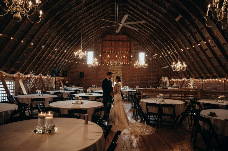 Married couple dancing in a lit up barn