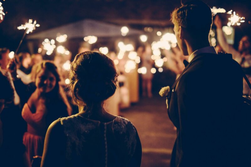 Couple looking at guests with fireworks