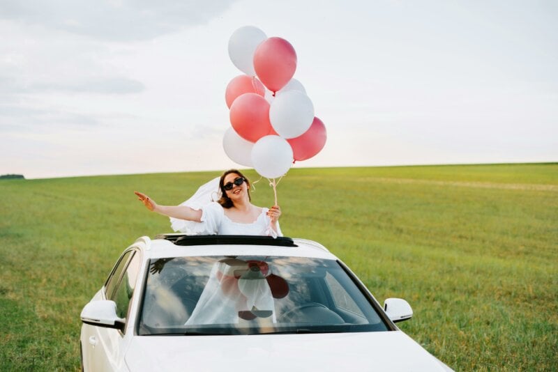 Bride in a car with balloons