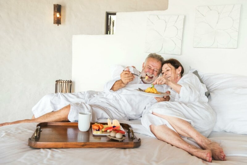 Couple en train de prendre un petit déjeuner au lit