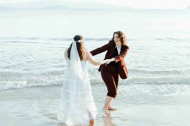 Mariées en train de danser sur une plage