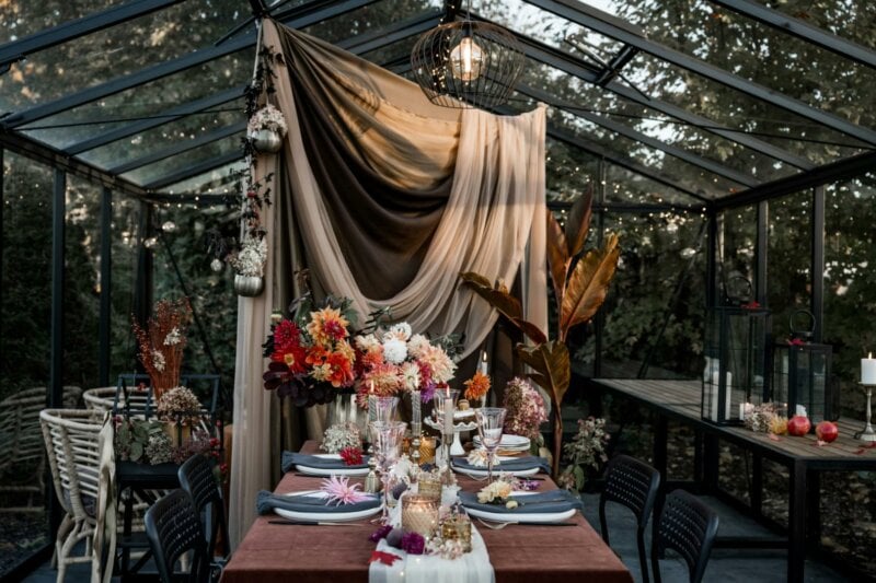 Wedding table with flowers and drape in a greenhouse