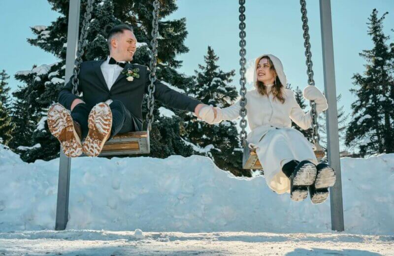 Couple de mariés sur une balançoire dans la neige