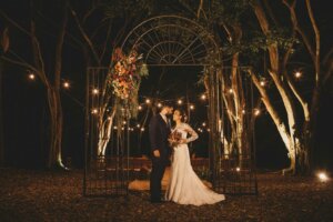 Married couple at an outdoor wedding with a flowered arch