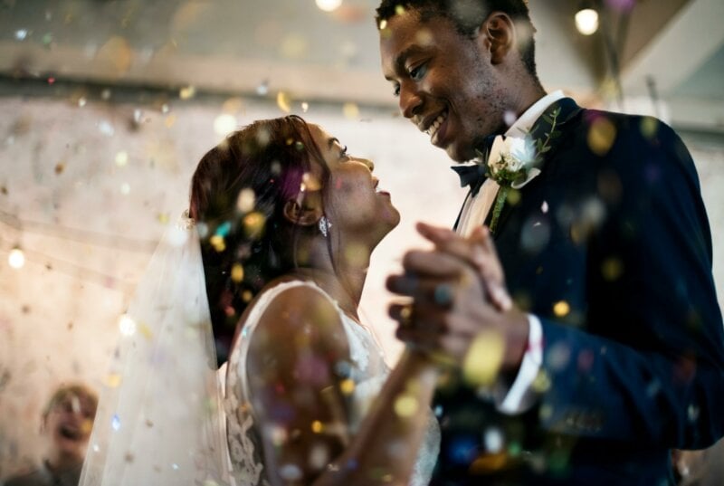 Couple de mariés en train de danser sous les confettis