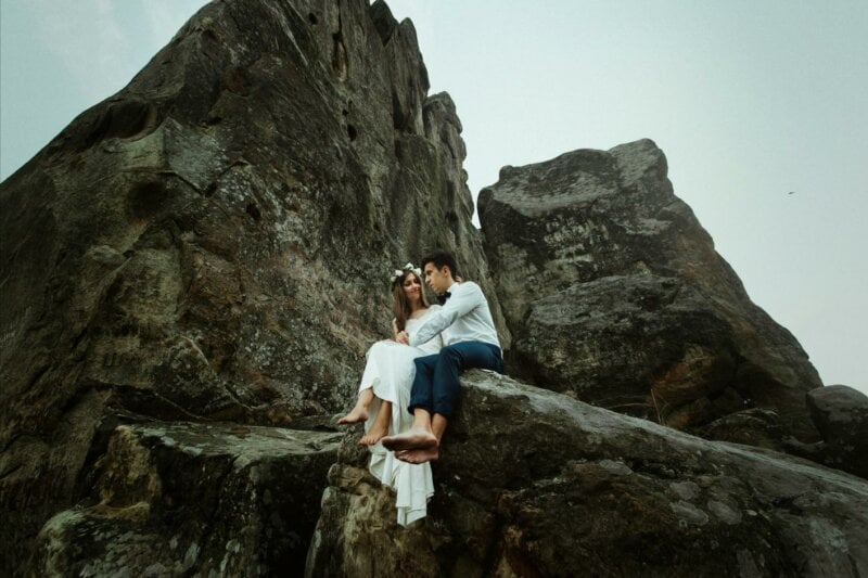 Couple de mariés assis sur un rocher