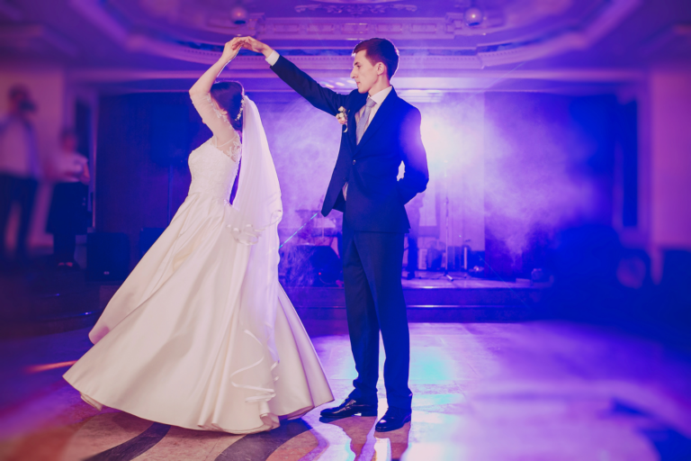 Couple de mariés en train de danser sous une lumière violette