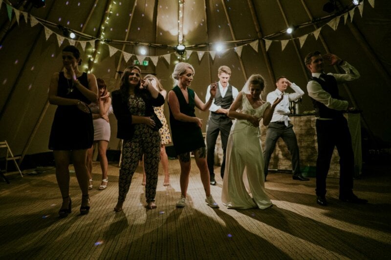 Bride and guests dancing in a wedding tent