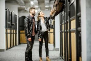 Couple portant du cuir dans une écurie