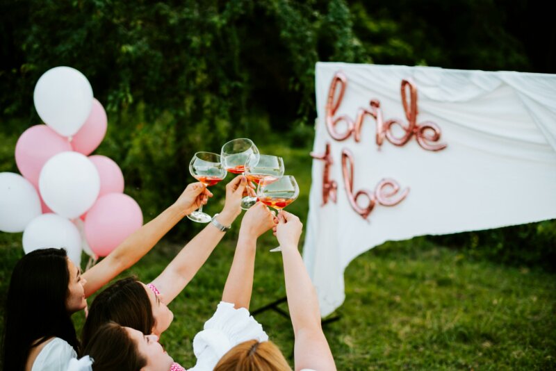 Women cheering to a bride to be sign