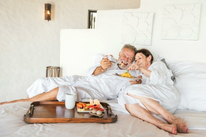 Couple en train de prendre le petit-déjeuner au lit