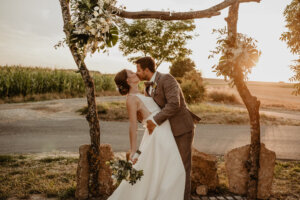 Hochzeitspaar küsst sich in der Natur