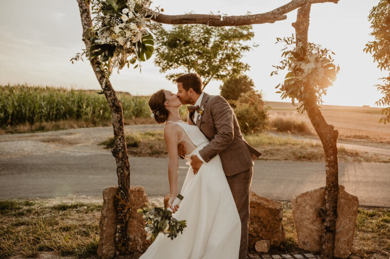 Hochzeitspaar küsst sich in der Natur