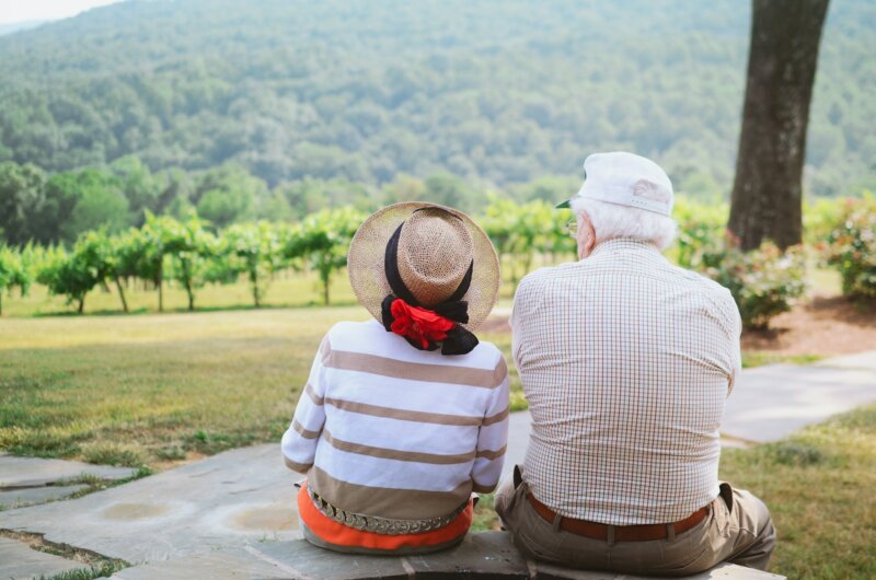 Mann und Frau sitzen nebeneinander und schauen in die Landschaft